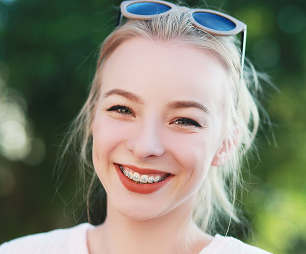 smiling young woman with traditional braces