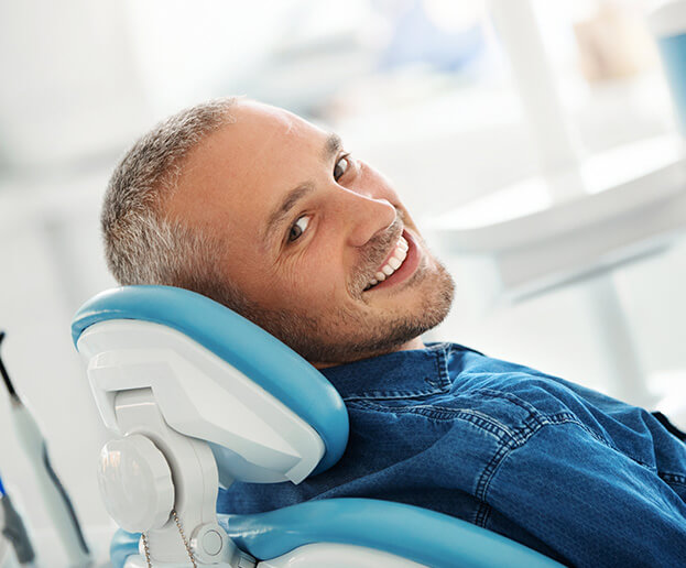 smiling man sitting in a dental chair