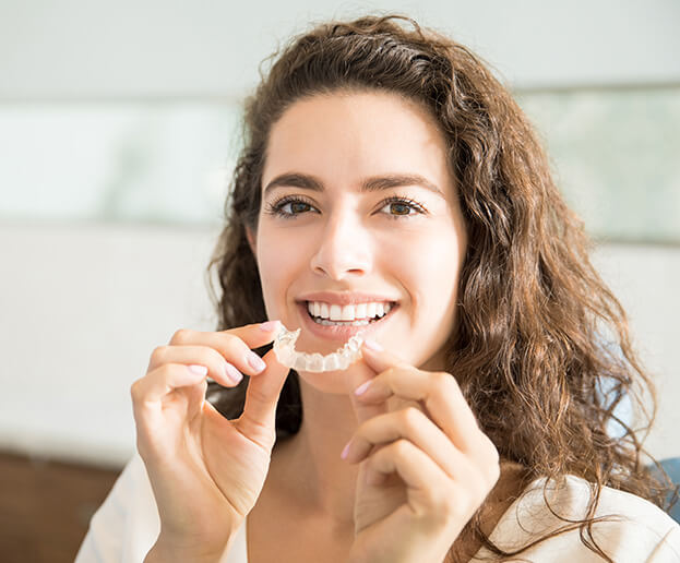 woman putting in her teeth aligners