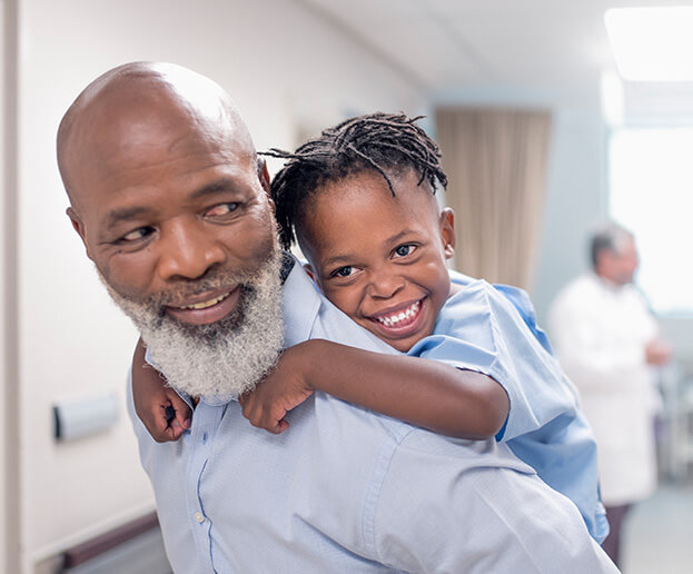 young boy hanging on his grandfather's back