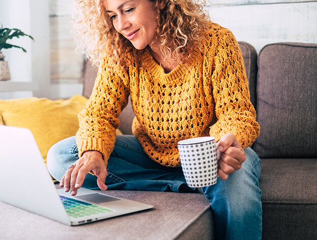 woman sipping coffee while working on her laptop